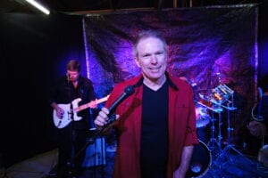 A man holding a microphone in front of some other people.