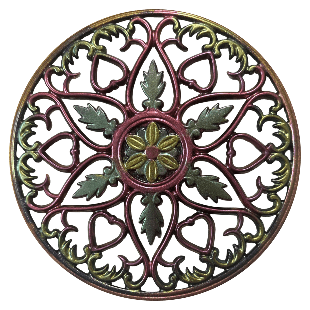A circular decorative metal work piece with green and red designs.